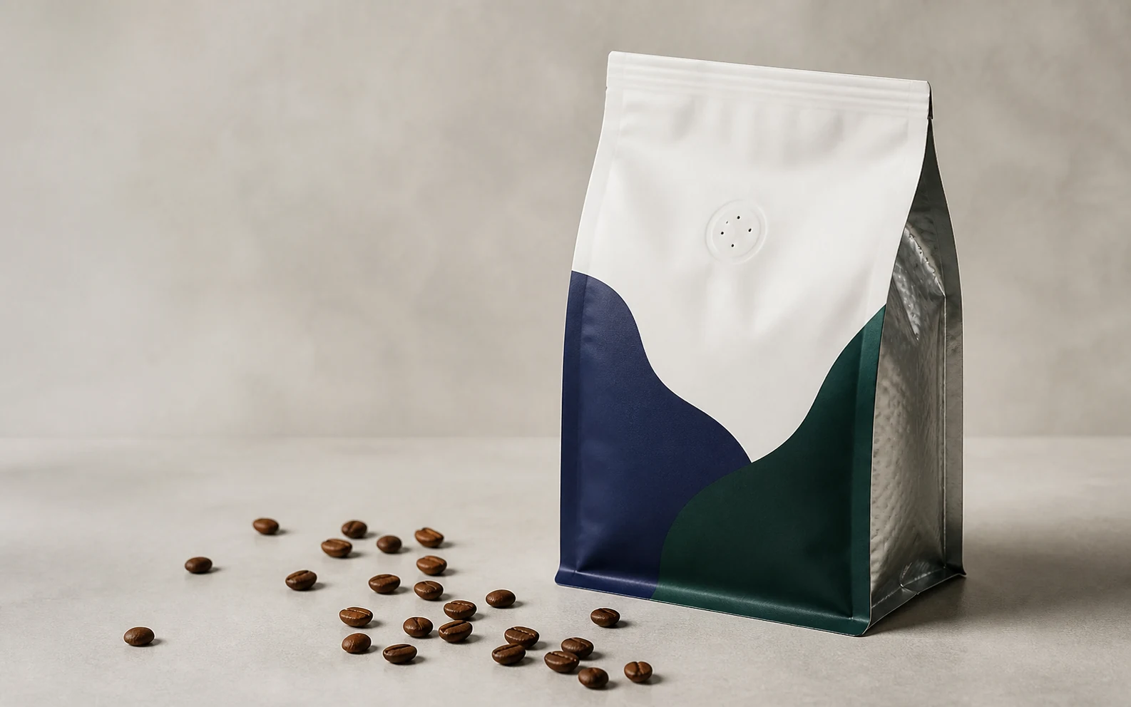 Matte valve coffee pouches beside roasted coffee beans